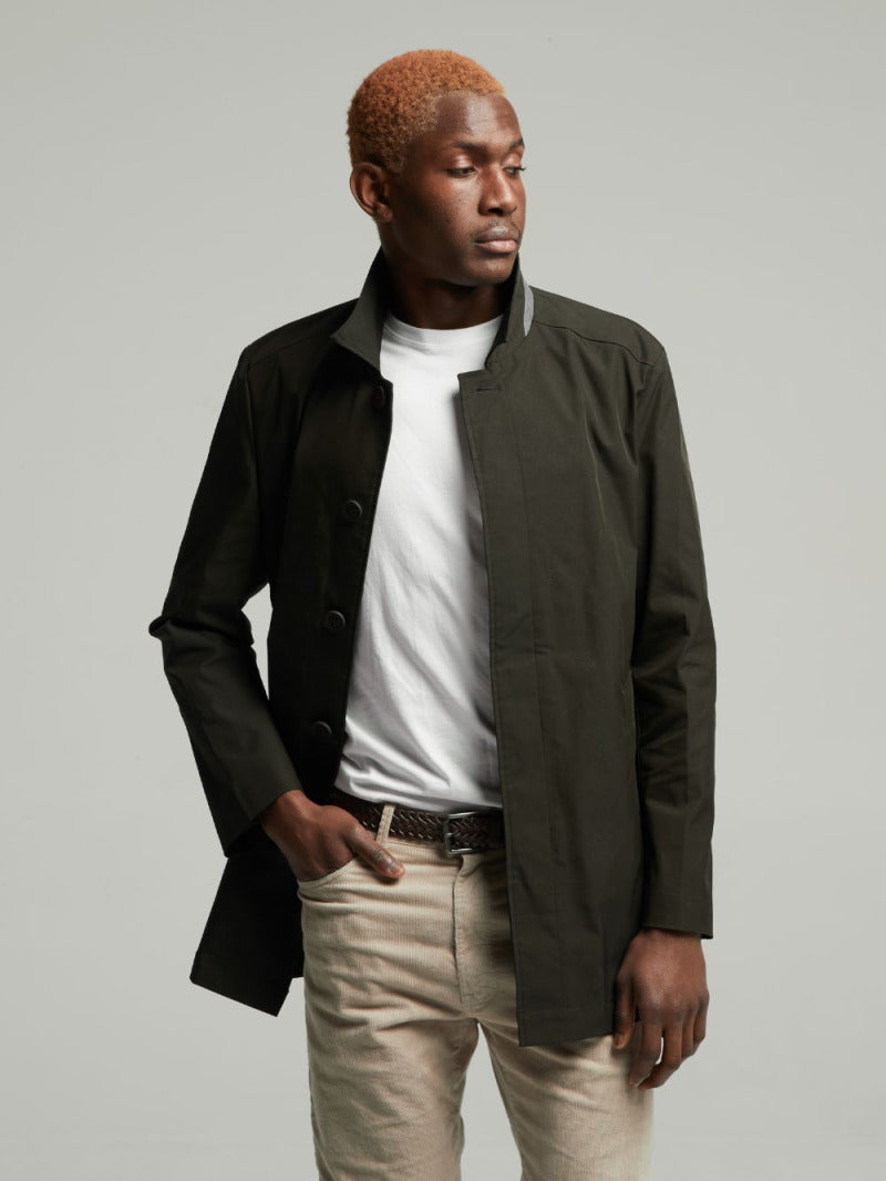 Wentworth Travel Raincoat in Black, worn open with stone chinos, three-quarter view