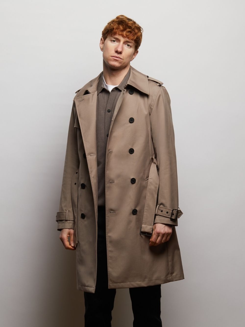Beacon trench coat in Putty worn open on a model, front view with cuff straps
