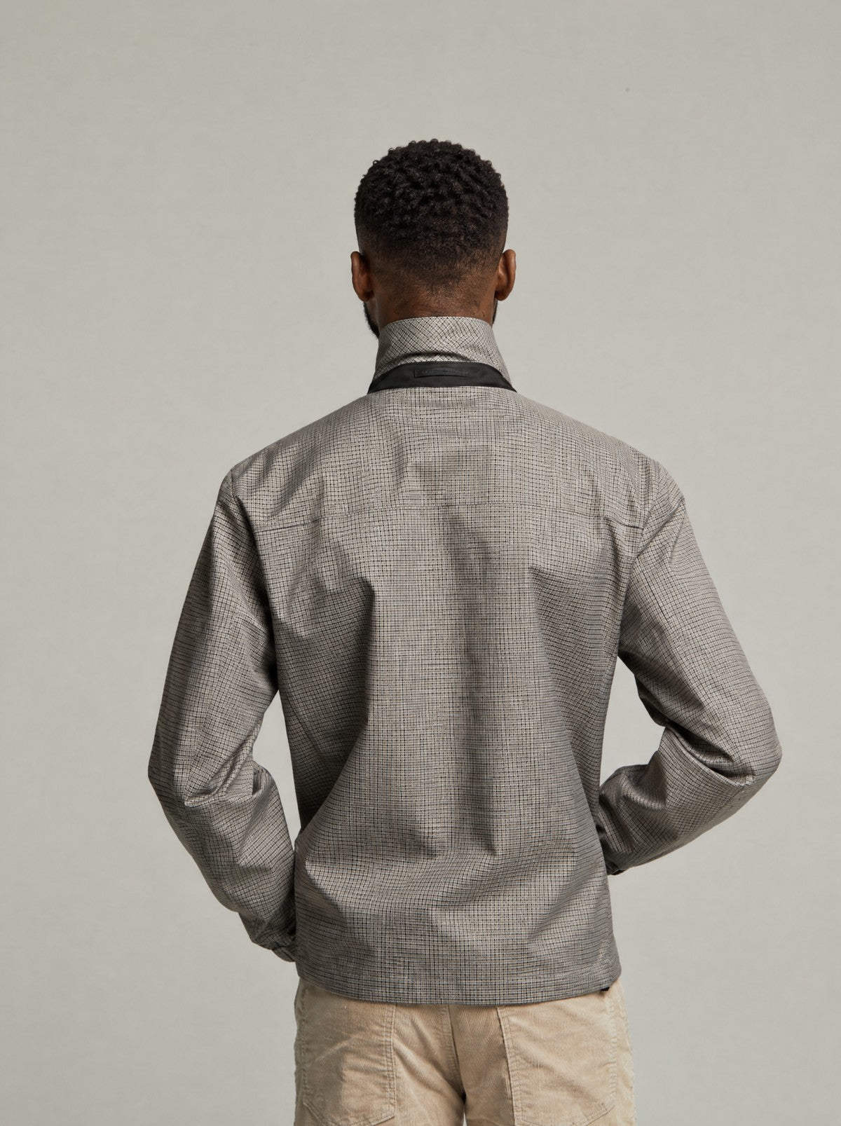 Back view of the Martelloz zip coach jacket in Check on a model