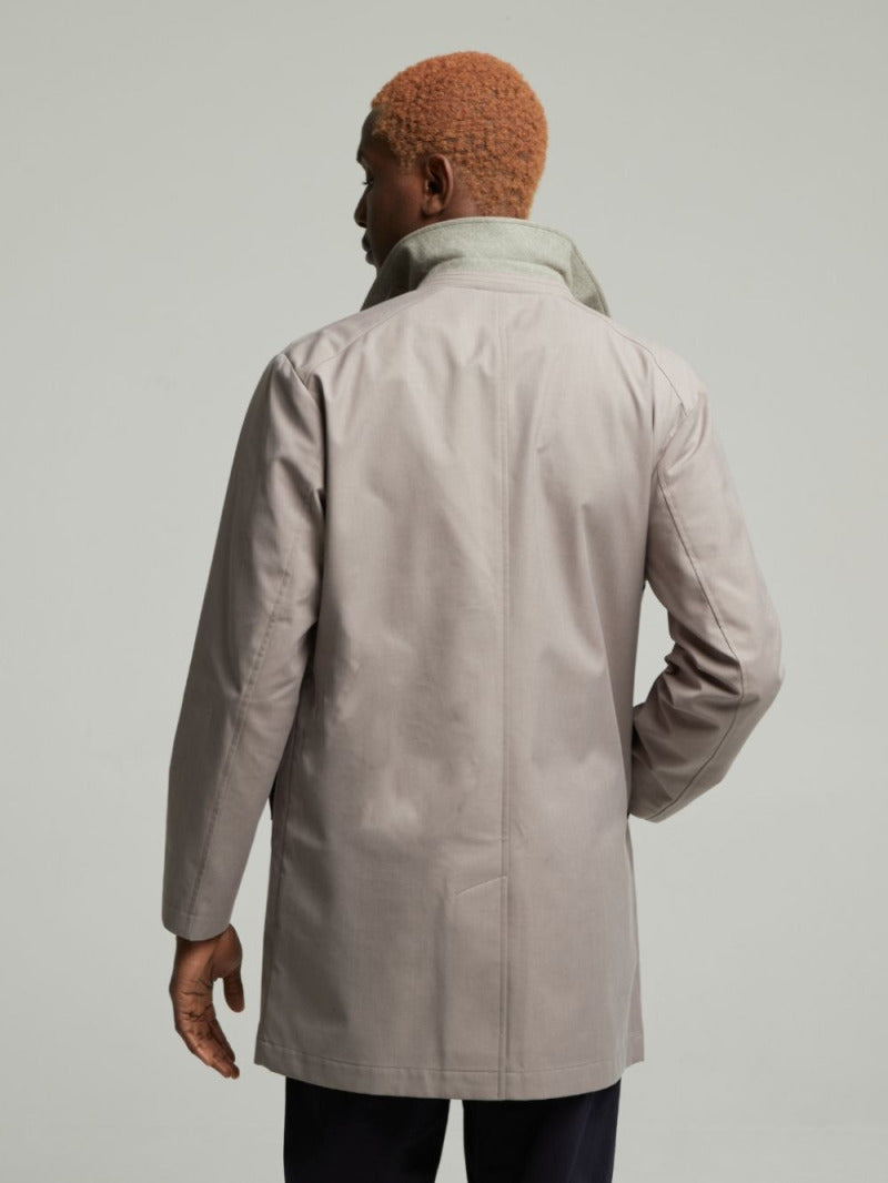 Back view of the Carver lightweight raincoat in Putty on a model