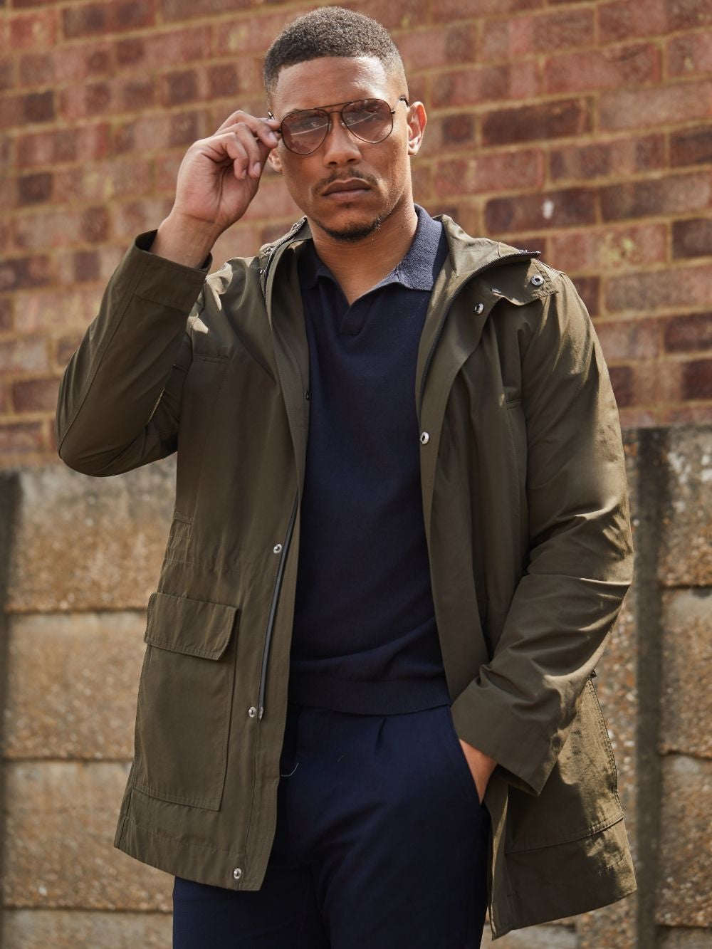 Blake lightweight parka in Khaki worn outdoors on a model with a navy polo