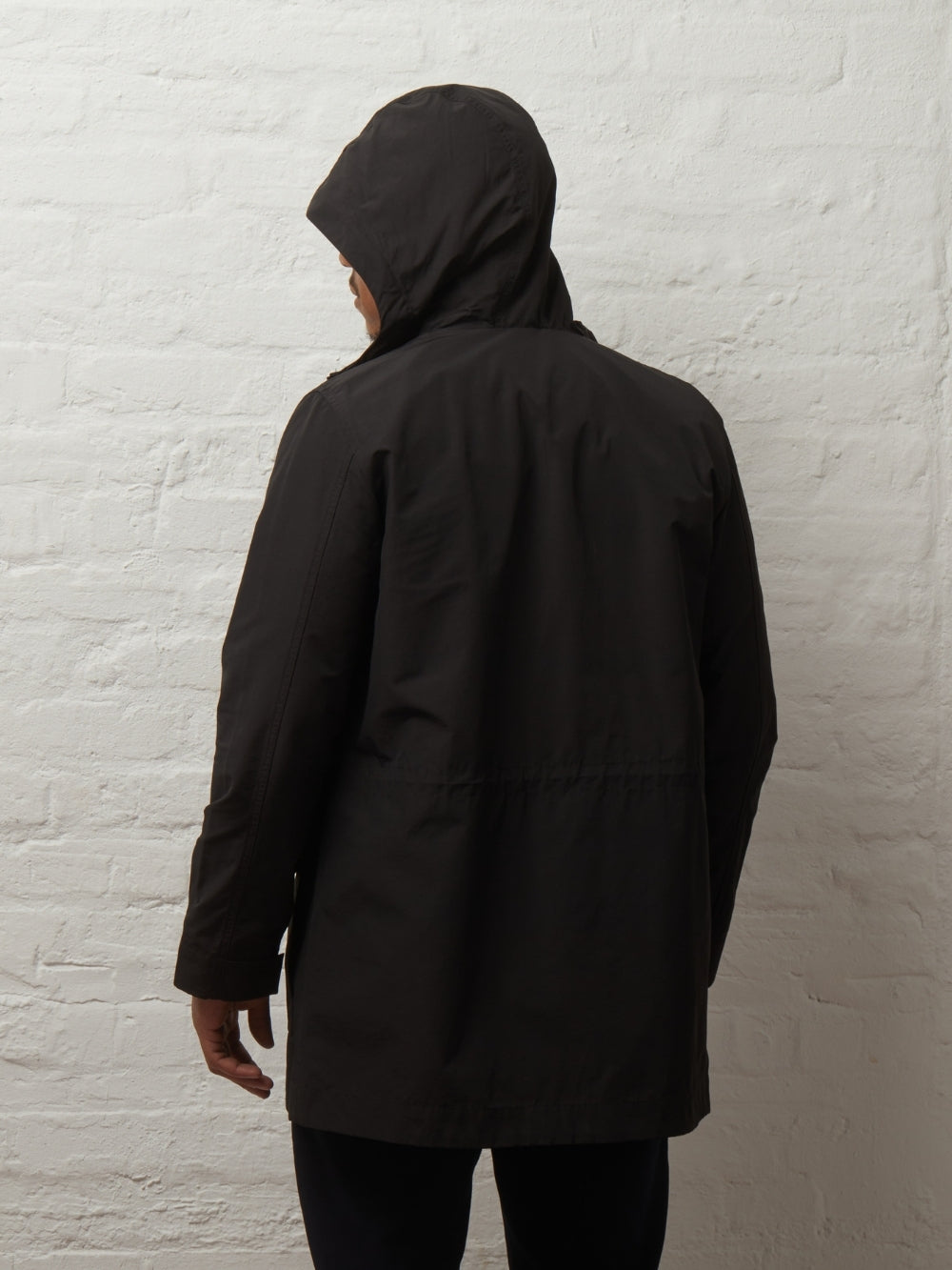 Back view of the Blake parka in Black on a model with the hood up