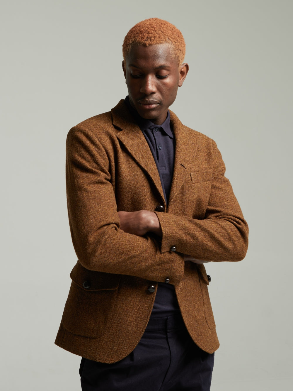 Guards London Allenby Wool Tweed Blazer in Brown worn on a model with a navy polo, arms folded