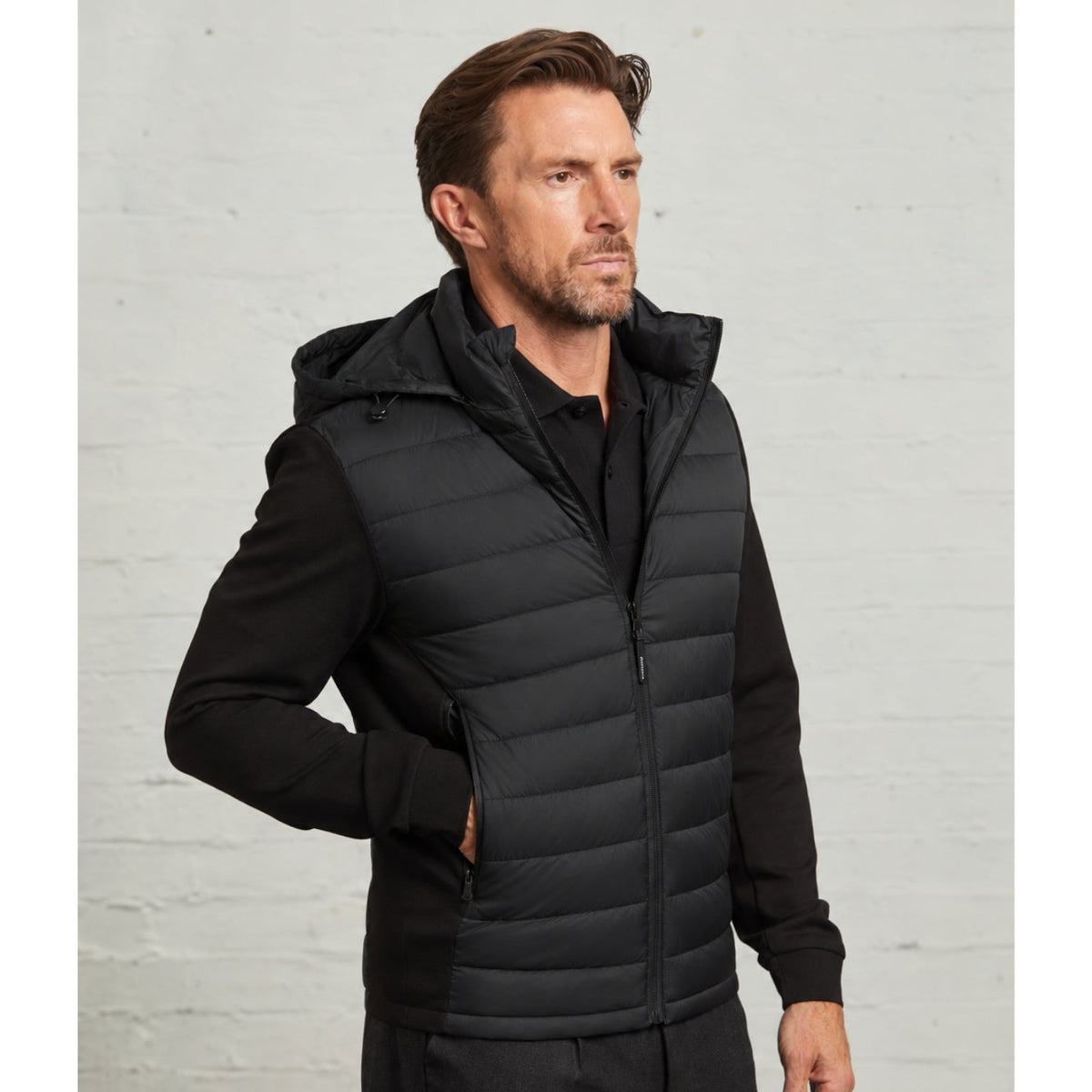 Guards London Bale Hybrid Quilt and Interlock Zip Jacket in Black worn on a model, hood down