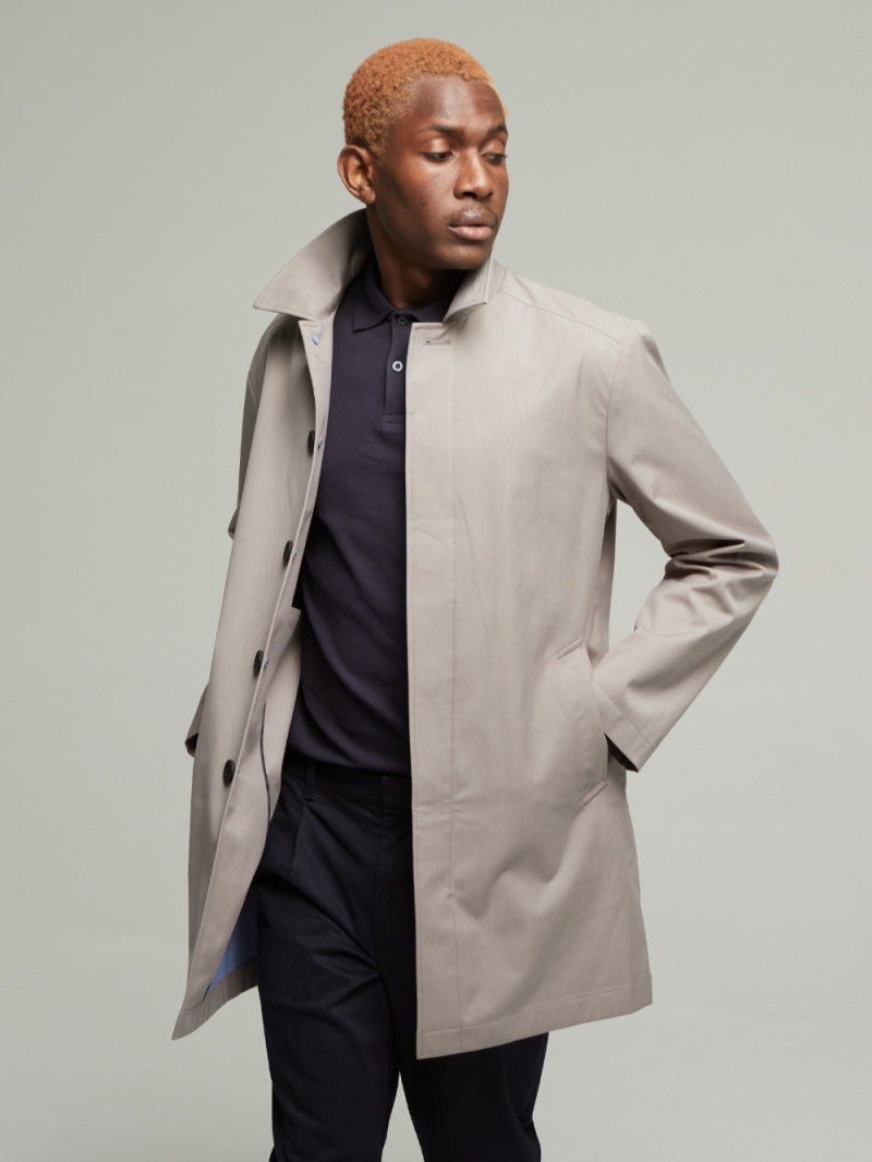 Guards London Carver Lightweight Raincoat in Putty worn open on a model over a navy polo