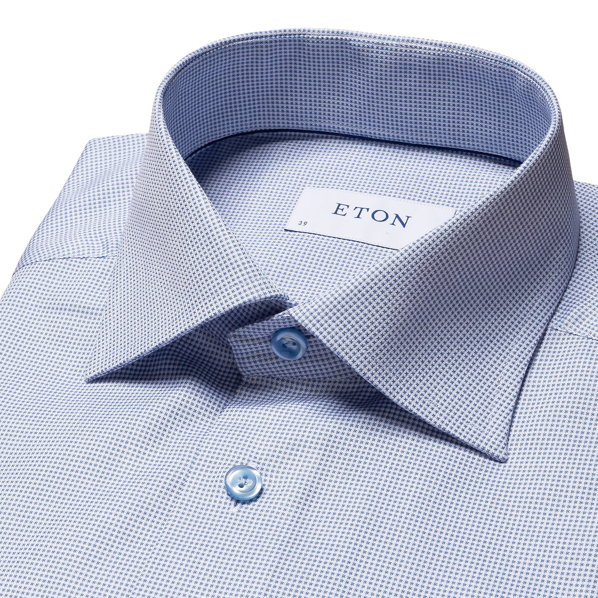 A blue shirt with a textured pattern and a visible brand tag that reads 'eton'.