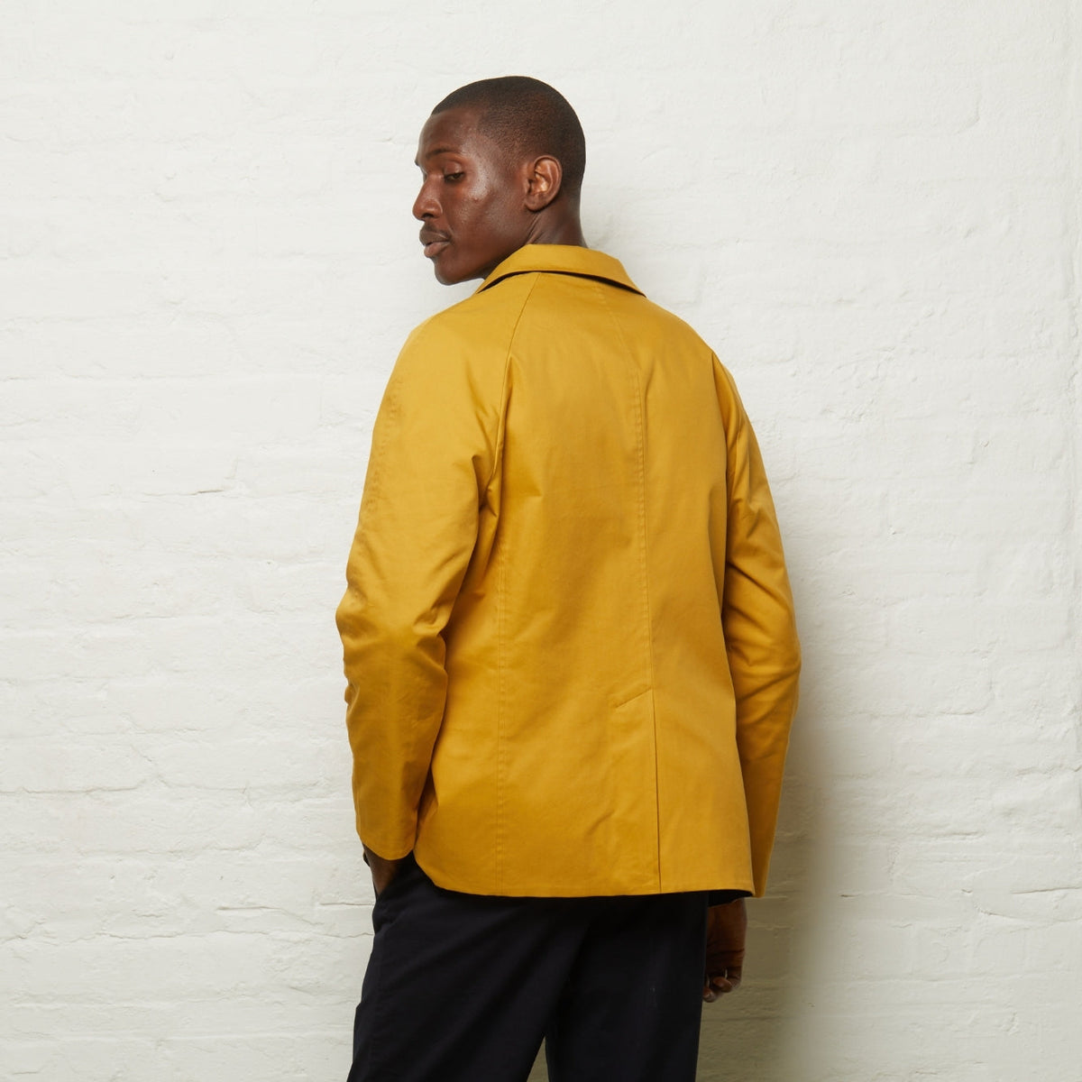 Fusilier Reversible Jacket in Gold/Navy, gold side out, back view on a model