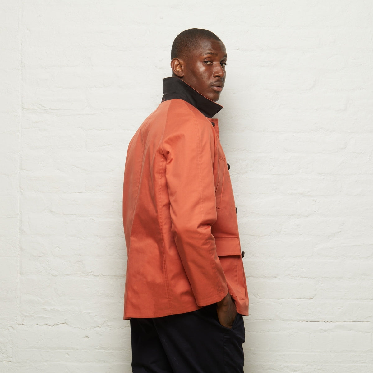 Fusilier Reversible Jacket in Orange/Black, orange side out, side and back view on a model