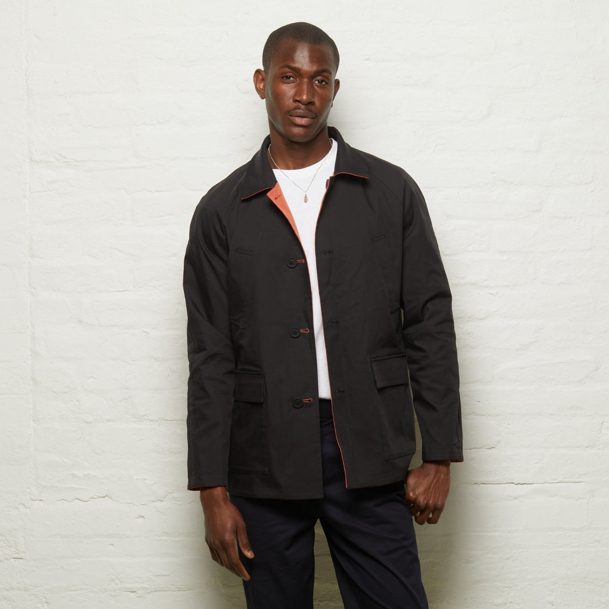 Fusilier Reversible Jacket in Orange/Black worn black side out, front view on a model