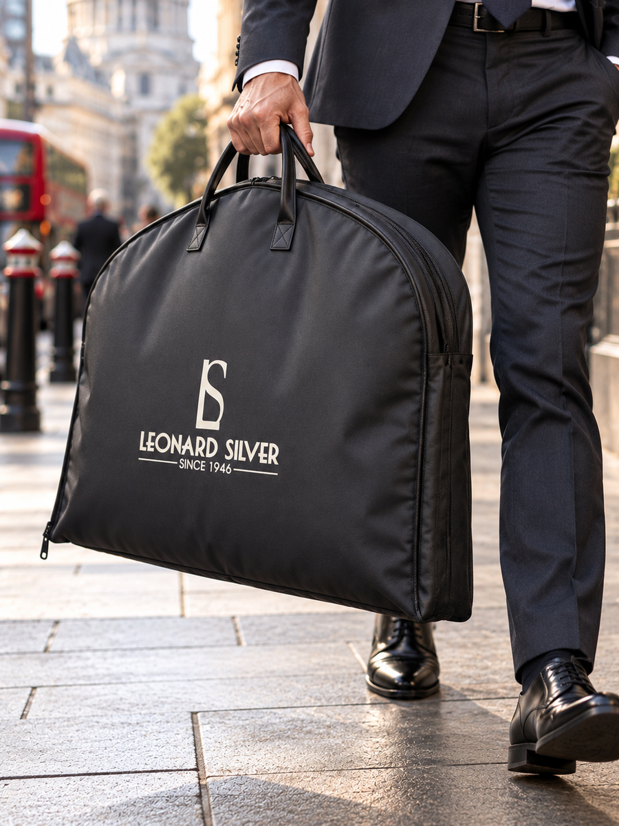 Black Leonard Silver suit bag carried by its handles, close view on a city street