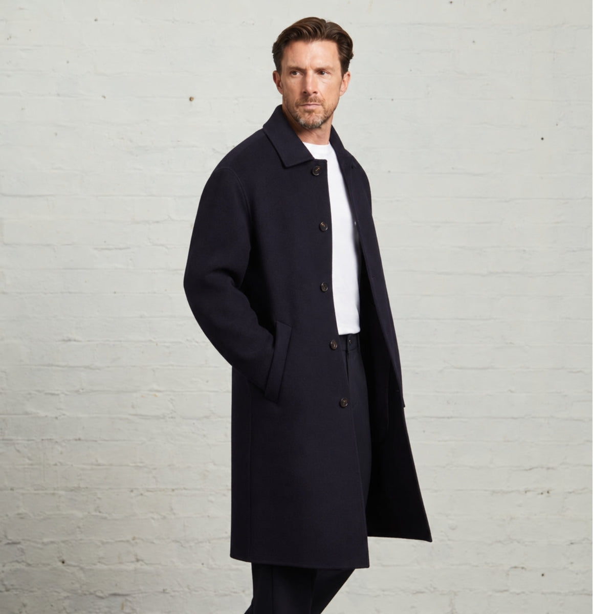 Navy Oscar overcoat worn open, three-quarter view