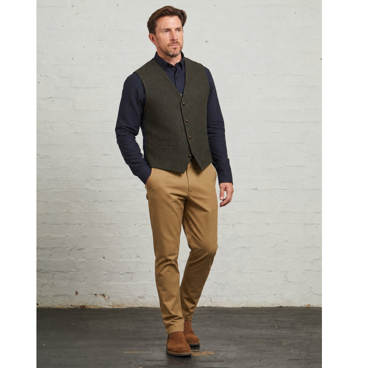 Robert herringbone waistcoat in Green, full-length view with tan chinos