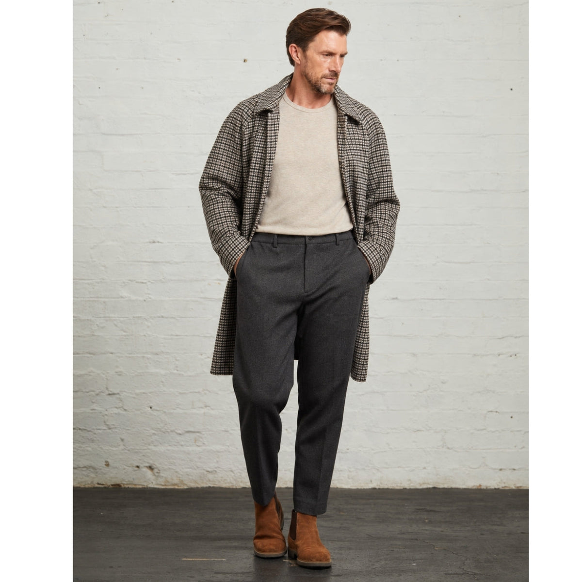 Full-length view of the Grey Walter check overcoat worn with charcoal trousers and brown boots