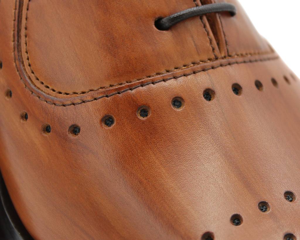 Close-up of the punched detail and hand-painted brown leather