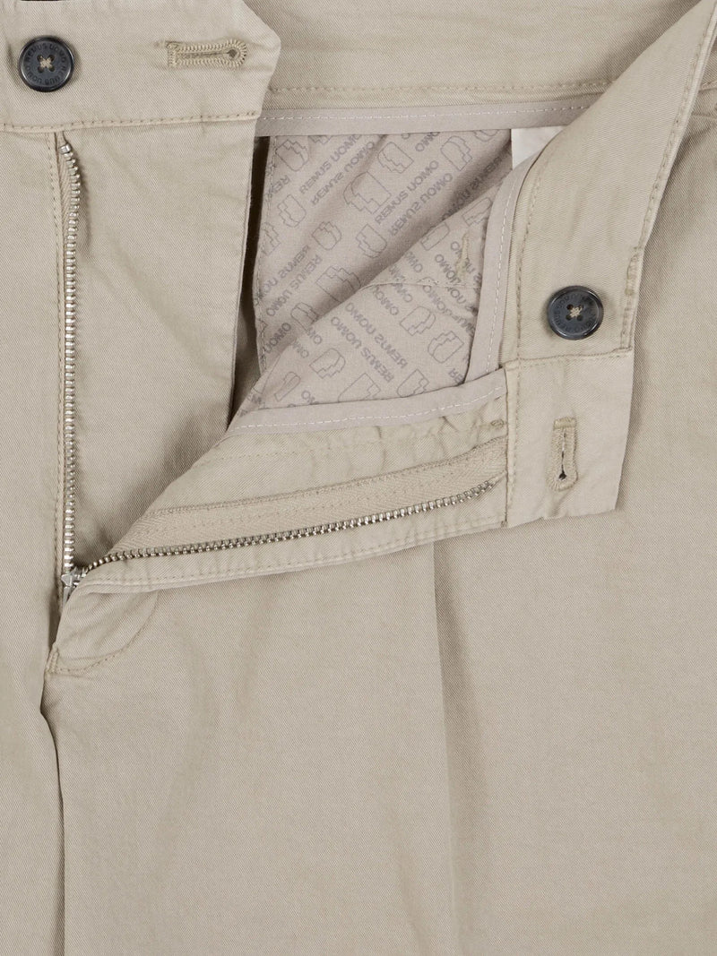 Close-up of beige pants with zippers and buttons